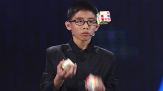 Новый рекорд: китайский подросток собрал три кубика Рубика, жонглируя ими